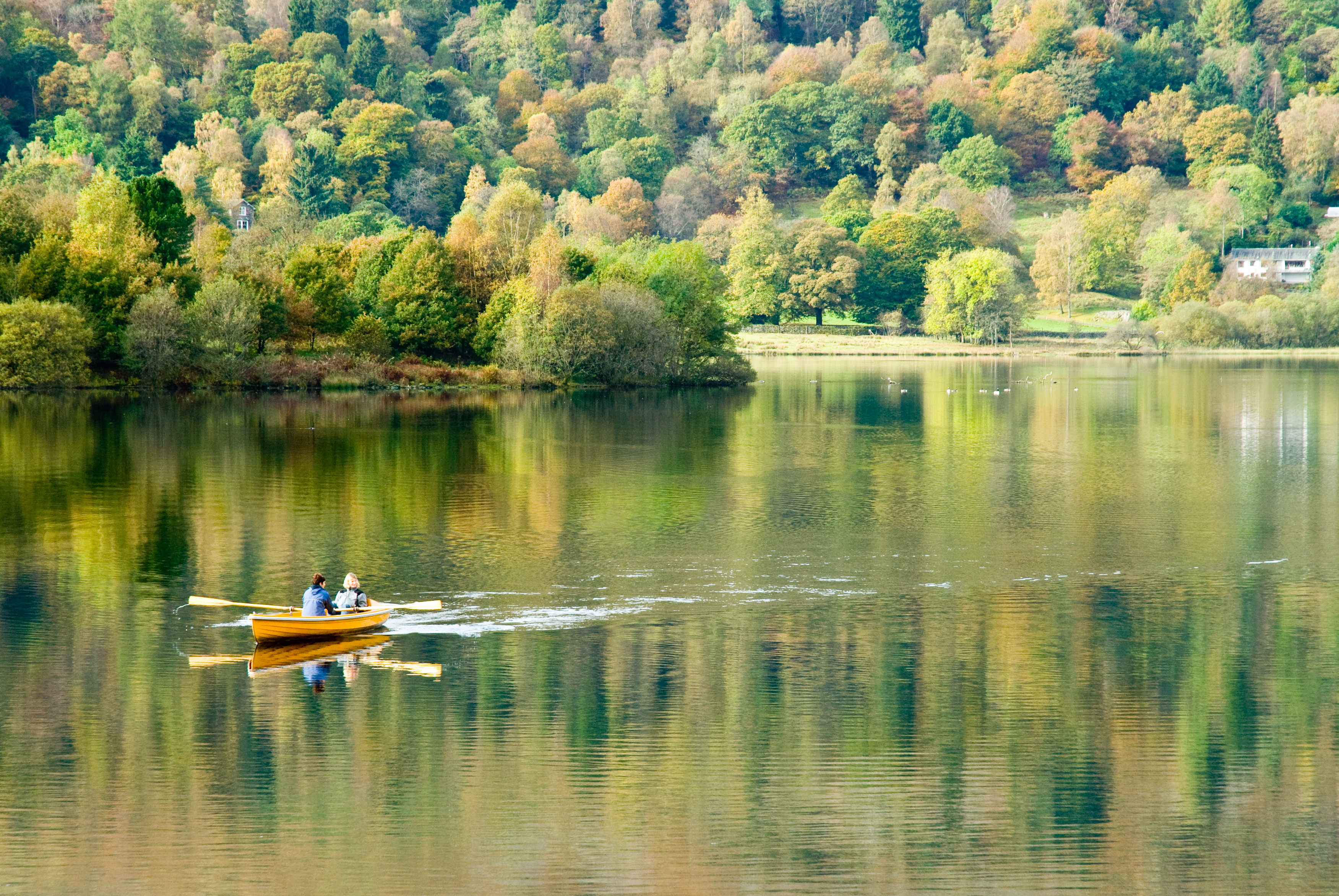 Here is a picturesque take on one of the towns/villages I have mentioned in this paragraph. Isn't this a fantastic photo of Grasmere Lake? Two canoeists row in the still deep silence of a glassy lake which reflects the beauty of its surroundings. (Photo courtesy of www.cumbriaphoto.co.uk.)