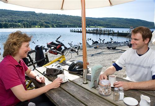 'Cyclists resting on the shore of Coniston Water by the Bluebird Cafe.' Photo by Ben Barden.